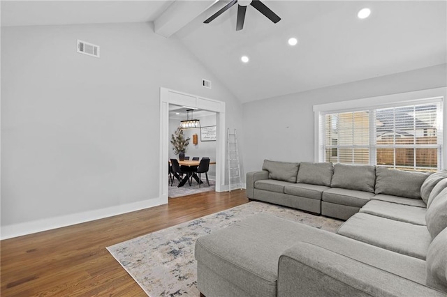 living room featuring visible vents, baseboards, a ceiling fan, and wood finished floors