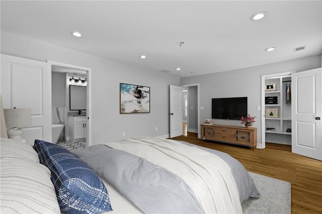 bedroom featuring recessed lighting, wood finished floors, visible vents, and ensuite bathroom