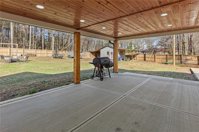 view of patio / terrace featuring area for grilling, an outdoor structure, and a fenced backyard