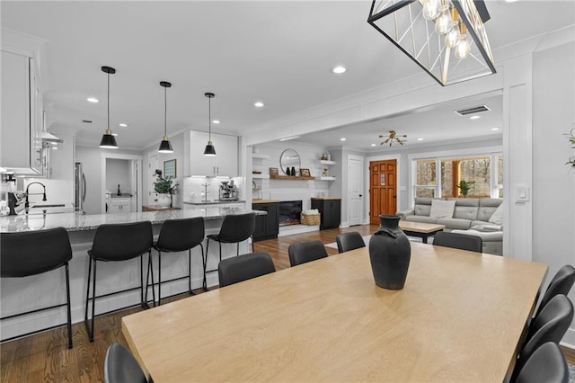 dining space featuring visible vents, ornamental molding, dark wood finished floors, recessed lighting, and a chandelier