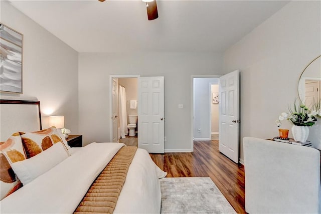 bedroom with ceiling fan, baseboards, ensuite bathroom, and wood finished floors