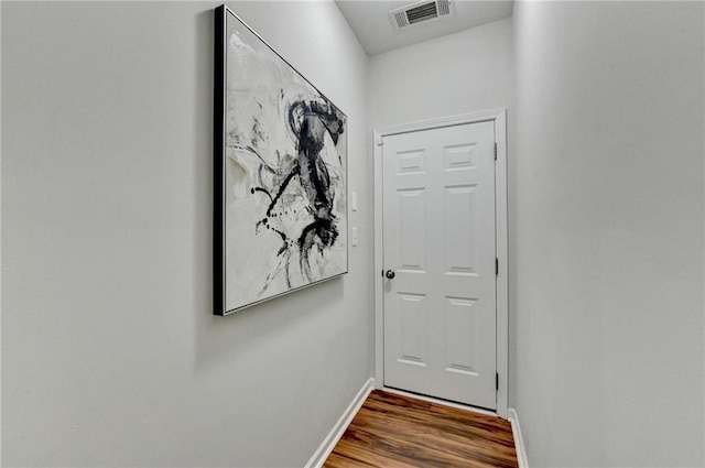 doorway with visible vents, baseboards, and wood finished floors