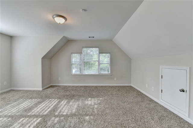 additional living space with carpet floors, baseboards, and lofted ceiling