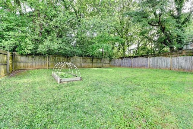 view of yard with a fenced backyard and a garden