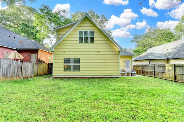 back of property featuring a fenced backyard and a yard
