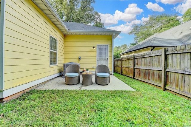 view of yard with central air condition unit, fence, and a patio area