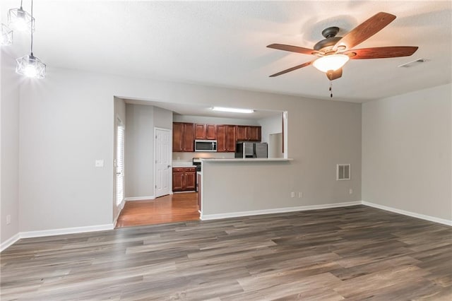 unfurnished living room featuring ceiling fan and hardwood / wood-style floors