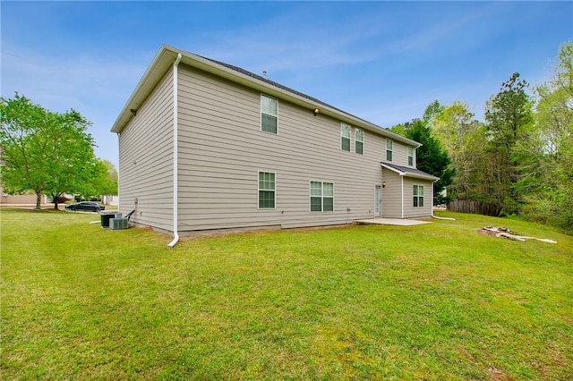 rear view of house with central AC unit, a patio area, and a yard