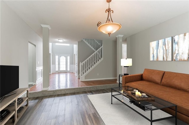 living room with decorative columns and dark hardwood / wood-style flooring