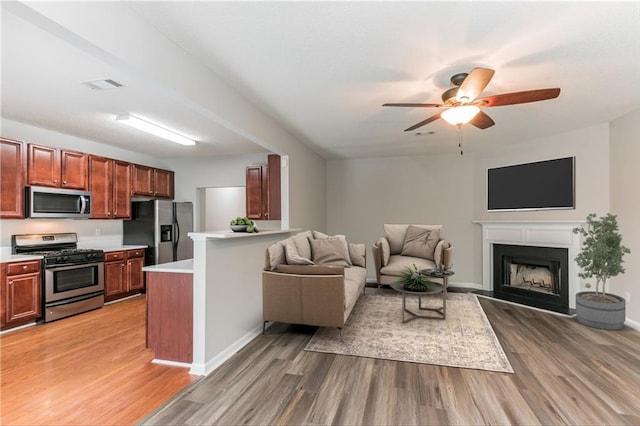 living room with light hardwood / wood-style floors and ceiling fan