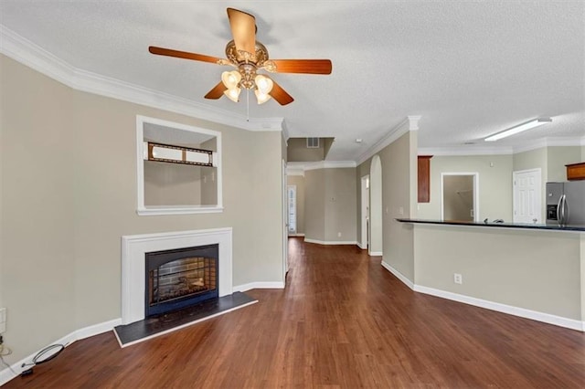 unfurnished living room with dark wood-type flooring, ceiling fan, crown molding, and a textured ceiling