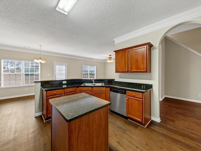 kitchen with sink, stainless steel dishwasher, plenty of natural light, kitchen peninsula, and pendant lighting