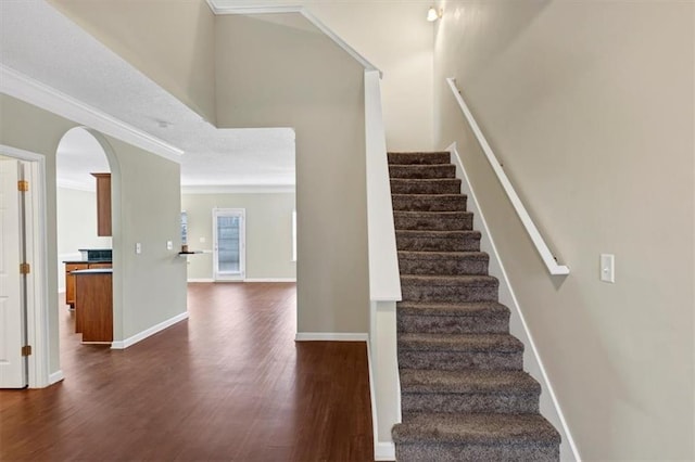 staircase featuring crown molding and hardwood / wood-style flooring