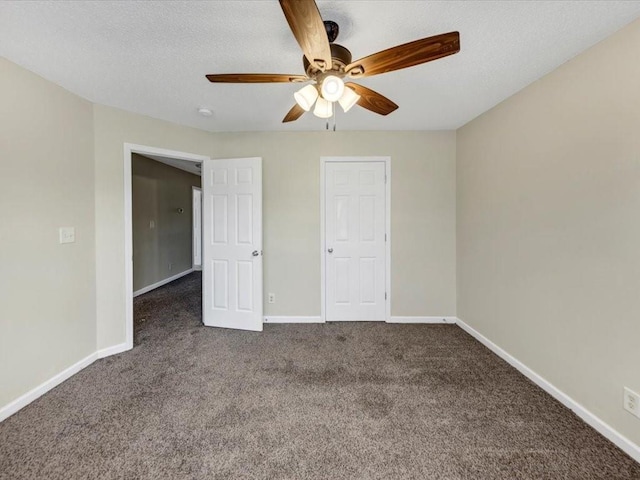 unfurnished bedroom featuring dark carpet, a textured ceiling, and ceiling fan