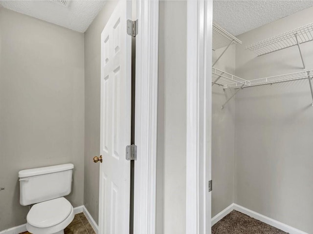 bathroom featuring toilet and a textured ceiling