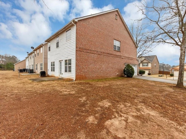 rear view of property featuring a garage and a patio area