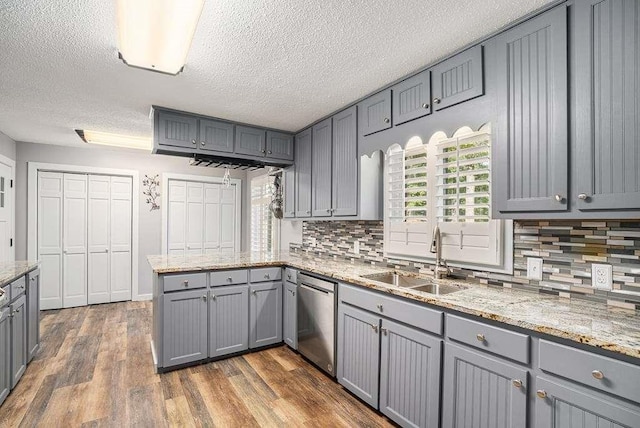 kitchen featuring gray cabinets, sink, stainless steel dishwasher, and dark hardwood / wood-style floors