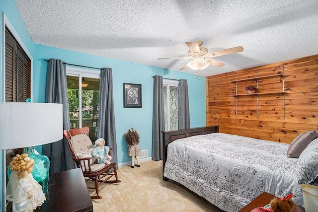 carpeted bedroom featuring ceiling fan and a textured ceiling