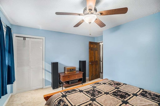 bedroom with ceiling fan, light colored carpet, a closet, and a textured ceiling