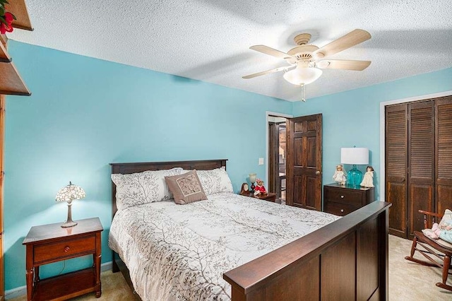 carpeted bedroom featuring ceiling fan, a closet, and a textured ceiling