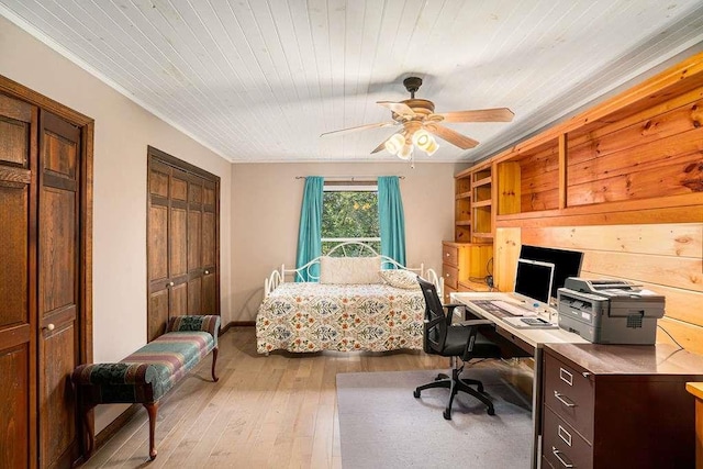 bedroom with two closets, wood ceiling, ceiling fan, and light wood-type flooring