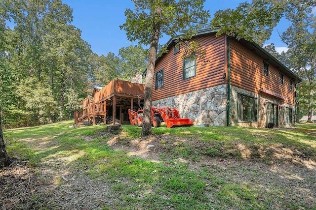 view of side of property featuring a wooden deck and a lawn