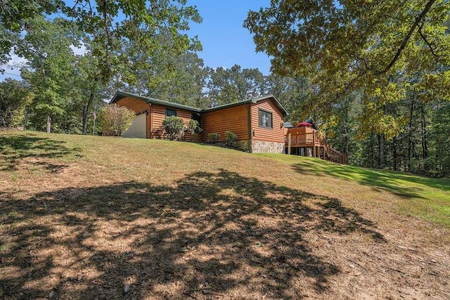 view of side of property with a wooden deck and a yard