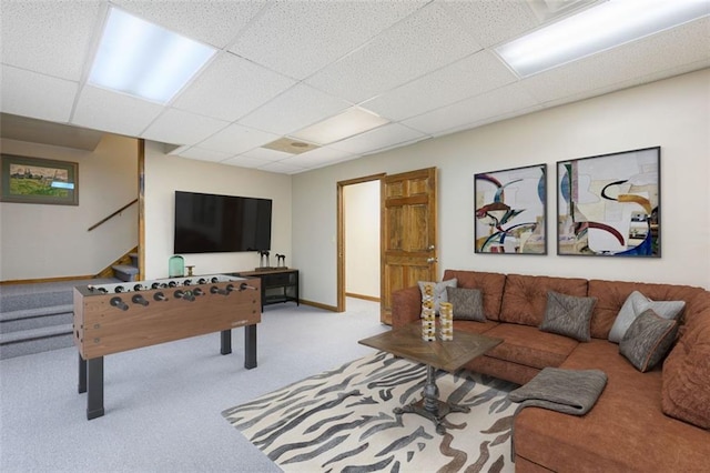 carpeted living room with a drop ceiling