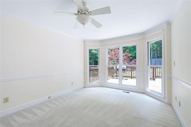 carpeted empty room featuring ceiling fan and crown molding