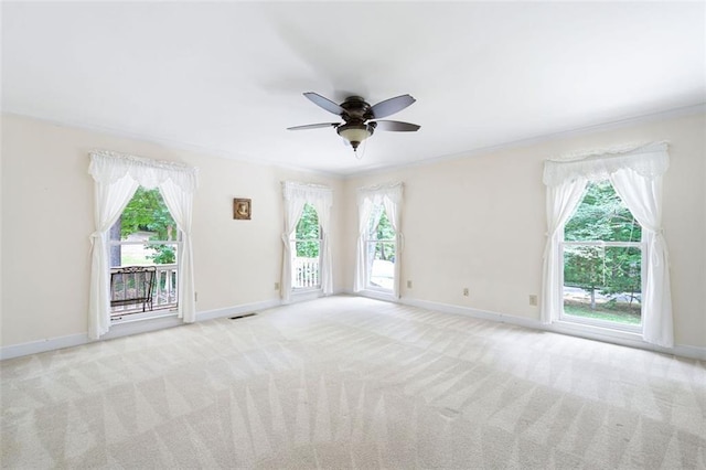 carpeted spare room featuring ceiling fan and crown molding