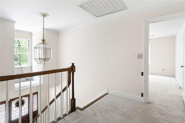 corridor featuring carpet floors, a notable chandelier, and ornamental molding