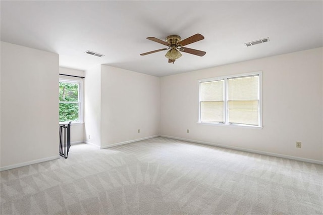 spare room featuring light carpet and ceiling fan