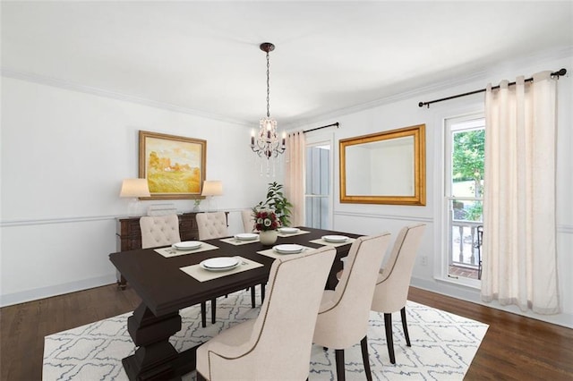 dining space featuring dark hardwood / wood-style flooring, crown molding, and an inviting chandelier