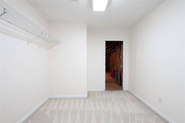 walk in closet with light colored carpet