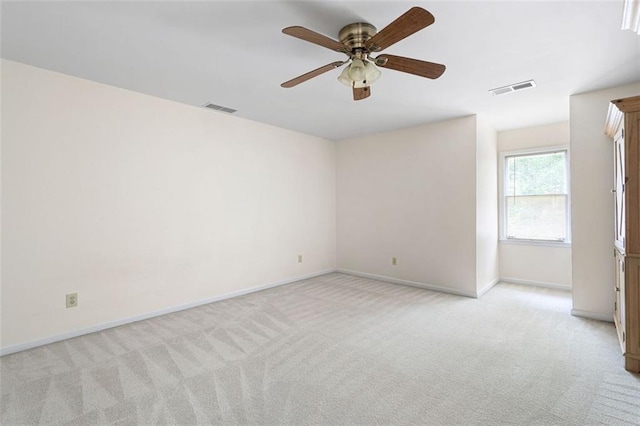 spare room with ceiling fan and light colored carpet