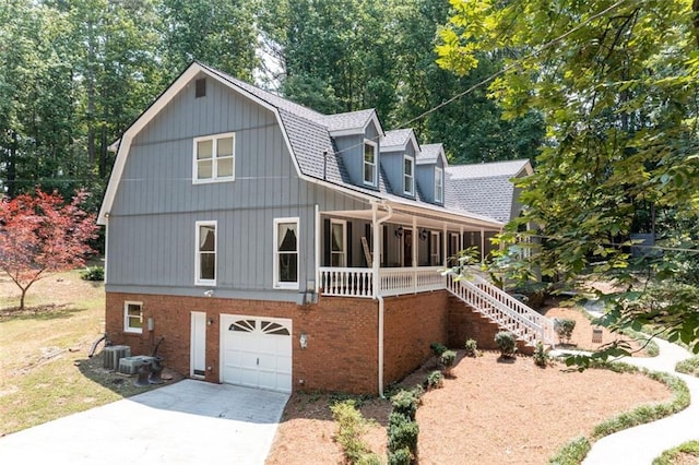 view of front of house featuring covered porch, a garage, and cooling unit