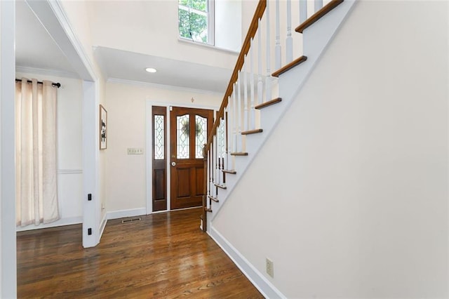 foyer with dark hardwood / wood-style floors, plenty of natural light, and crown molding