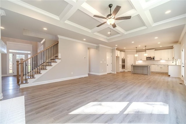 unfurnished living room featuring ceiling fan, light hardwood / wood-style flooring, crown molding, and coffered ceiling