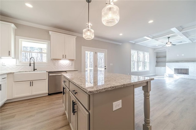 kitchen with white cabinetry, dishwasher, a center island, and light hardwood / wood-style flooring