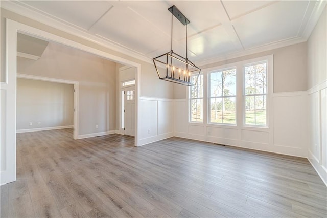 unfurnished dining area featuring a notable chandelier, light hardwood / wood-style floors, and ornamental molding