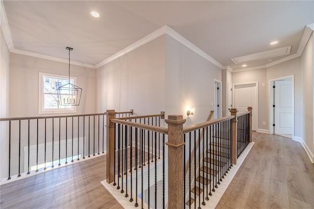 hall featuring a notable chandelier, ornamental molding, and light hardwood / wood-style flooring