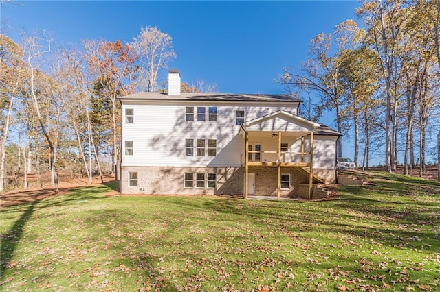 back of property with a lawn, a wooden deck, and ceiling fan