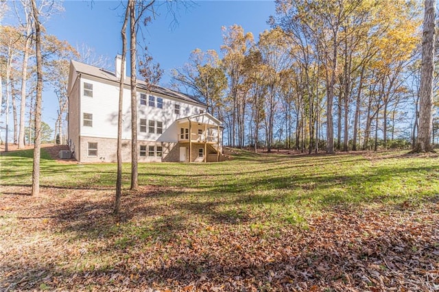 back of house featuring a wooden deck and a lawn