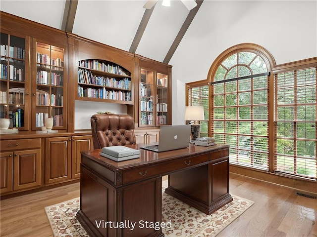 home office with visible vents, ceiling fan, beamed ceiling, light wood-type flooring, and high vaulted ceiling