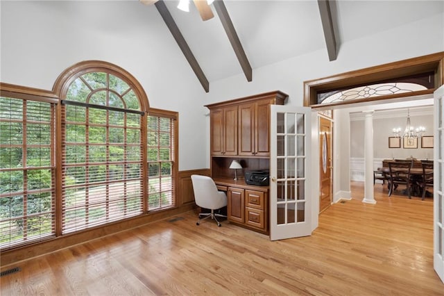 office space with beamed ceiling, built in desk, wainscoting, high vaulted ceiling, and ornate columns