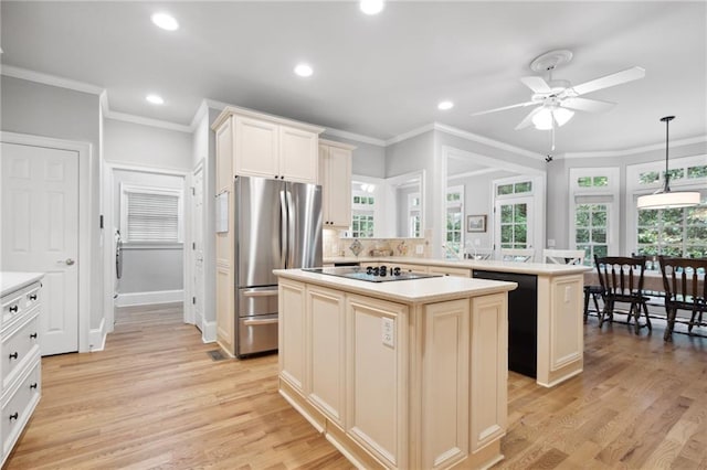 kitchen with black appliances, light countertops, light wood finished floors, and a kitchen island