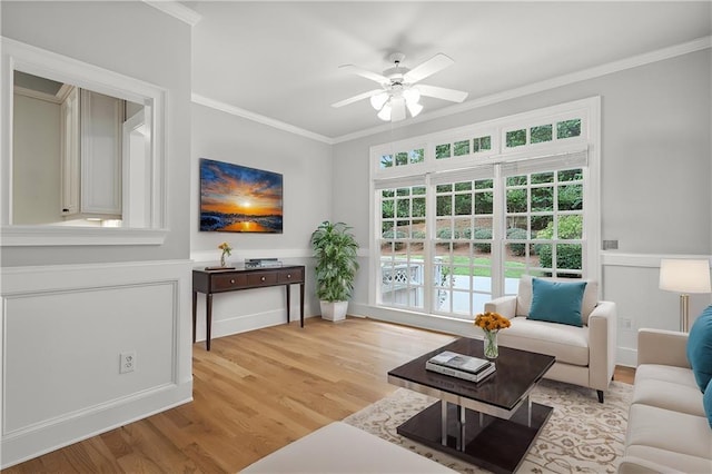 living room with a ceiling fan, wood finished floors, and ornamental molding