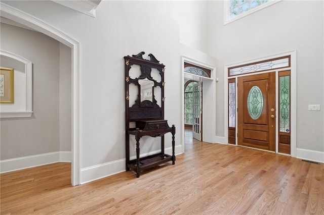 entryway with light wood-style flooring, baseboards, and a healthy amount of sunlight