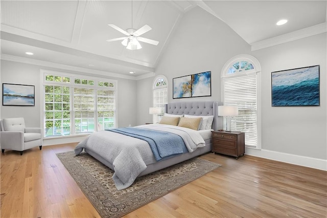 bedroom with ceiling fan, baseboards, light wood-type flooring, ornamental molding, and high vaulted ceiling