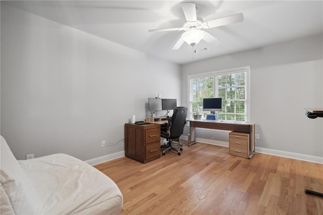 office space with visible vents, baseboards, light wood-style floors, and ceiling fan